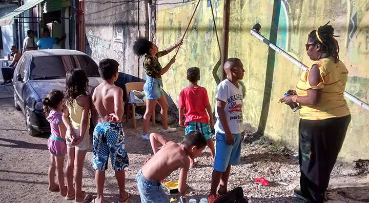Crianças da comunidade interagindo com as grafiteiras.