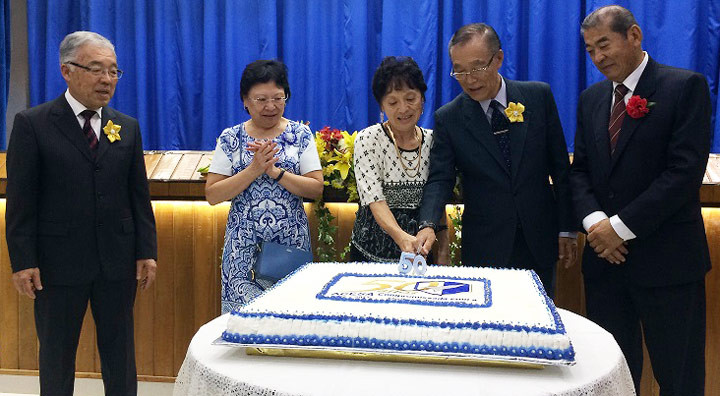 Presidente Mario Suga e esposa cortam bolo comemorativo.