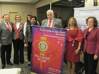 Presidente Fabrizio, com amigos, segura o banner.