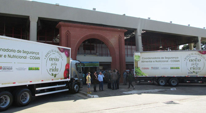 Frente do novo Centro, com caminhões de distribuição de alimentos.